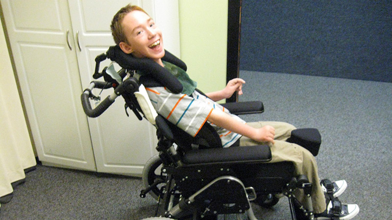 Smiling Young Man in Seating Dynamics Wheelchair